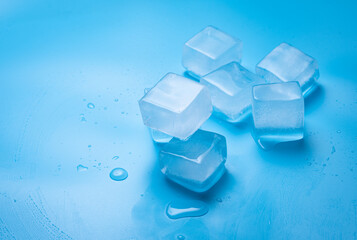 Ice cubes with water drops on a blue background