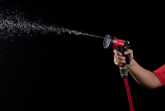  Hand Hold A Gun Watering Hose With Water Splash Against On Black Background,spraying Hose Nozzle