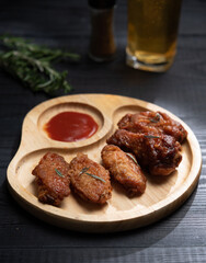 Baked chicken wings and chili sauce on the table