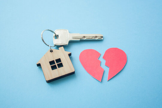 Wooden house toy and silver key with broken heart on bright pink background. Mortgage, house buy sell, investment, rent, realtor concept, cheating, problems and poverty concept