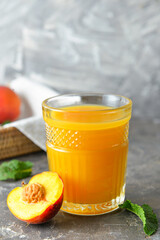 Glass of fresh peach juice on table
