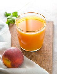 Glass of fresh peach juice on table