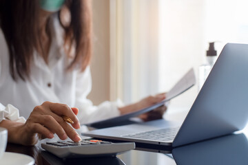 Woman using calculator, work on laptop computer