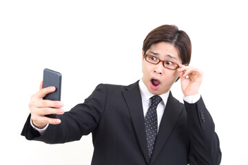 ビジネスマン　スマートフォンを見て驚く