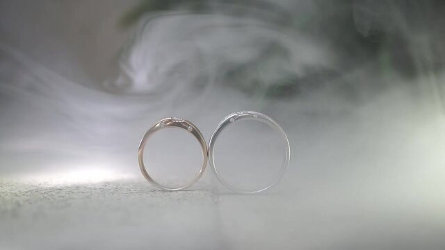 wedding rings on a floor with smoke