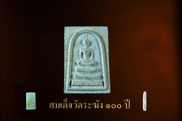 Thai ancient amulet 100 years celebrity on brown baclground