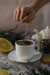lavender tea in a white mug. Purple tea in a mug on a light background stands on the table next to lavender flowers