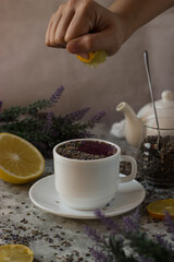 lavender tea in a white mug. Purple tea in a mug on a light background stands on the table next to lavender flowers
