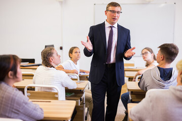 Fototapeta na wymiar Male speaker giving lesson for teenage students in classroom