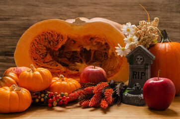 Mesa con decoración otoñal y halloween, con calabazas, flores y vela.