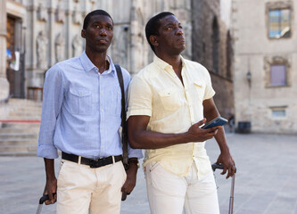 Happy travellers with suitcases visiting sights of European city
