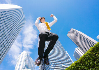 ビジネスマン　ジャンプ　快晴　青空　ビジネス街