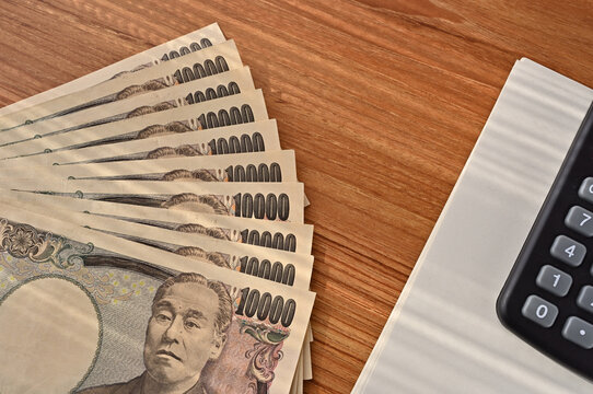 There were 10 Japanese 10,000 yen bills and a calculator on the table. The banknotes are Bank of Japan notes. The character depicted is Fukuzawa Yukichi.