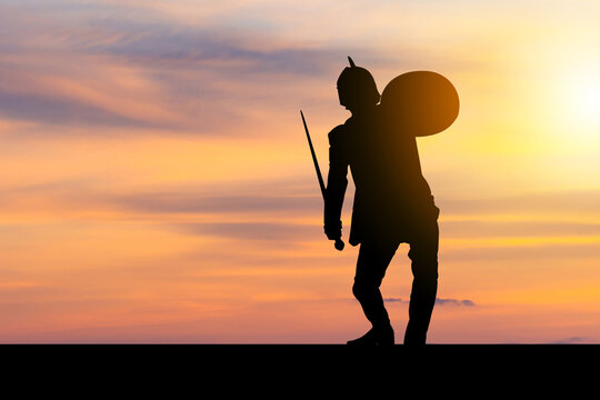 Silhouette of Business man in Knight Sword and Shield costume with clipping path sunset background, Fighting Business Warrior Concept.