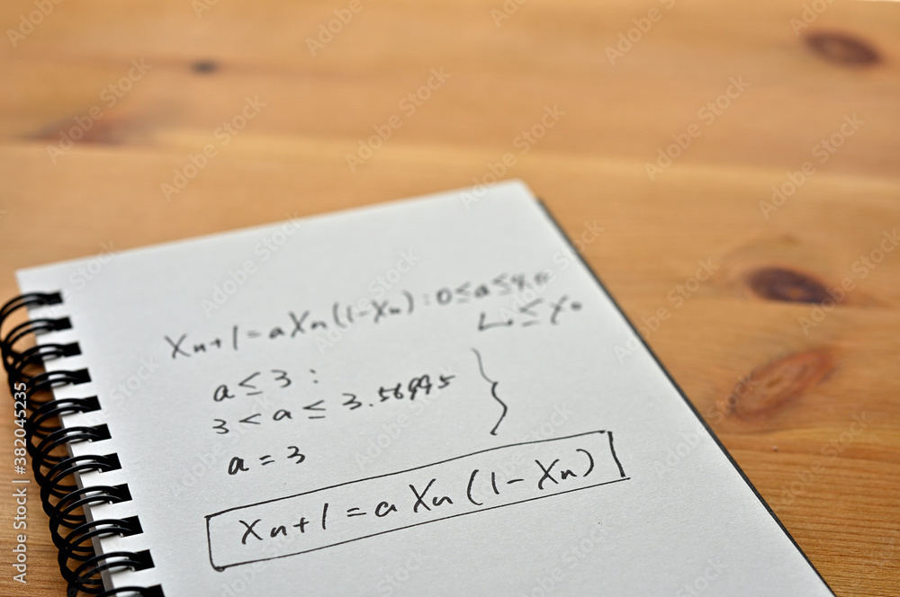 Poster a notebook with chaos theory formulas on it sits by the window.