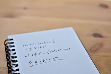 A notebook with the formula for the Pythagorean theorem sits by the window.