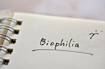 At the edge of the notebook, "Biophilia" is written. Close-up.