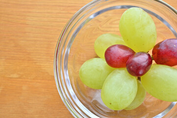 A small amount of grapes in a glass vessel.