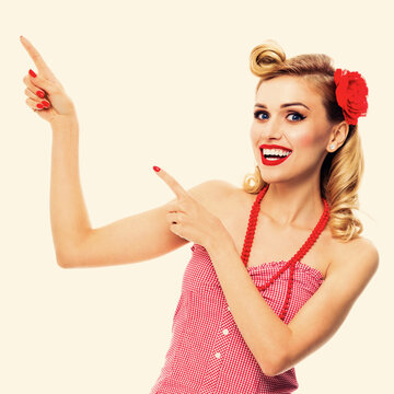 Amazed happy woman pointing at something. Excited girl in pin up, showing product or copy space for text. Retro fashion and vintage. Square.