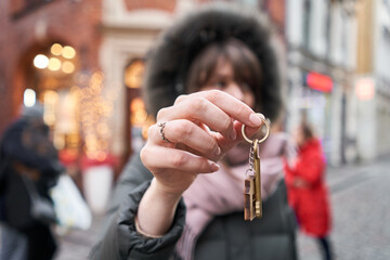 Mortgage or rent concept. Womans holding key with wooden house keychain . Real estate, hypothec,...