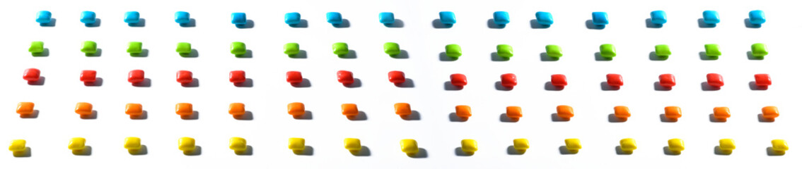 Banner. Colorful candies , dragee, chewing gum are placed in a row with a contrasting shadow on a white isolated background with focus stacking. Advertising label design element. Full depth of field.