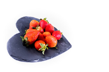 ripe strawberries on a black schist.