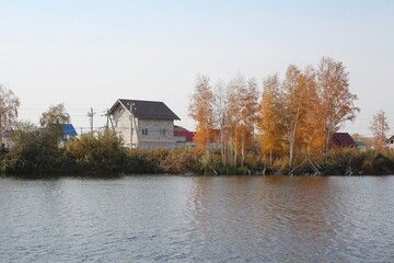 house cottage on the river Bank in autumn by the lake