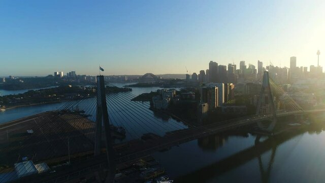 Aerial view of ANZAC Bridge and Sydney skyline during sunset, pull back reveal