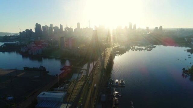 Rotating aerial view of ANZAC Bridge and Sydney skyline during sunset