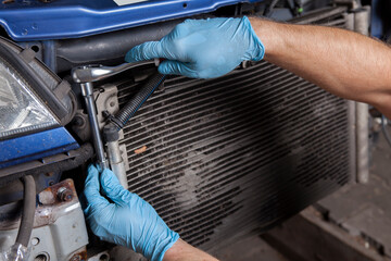 the mechanic pulls out an old leaky car radiator