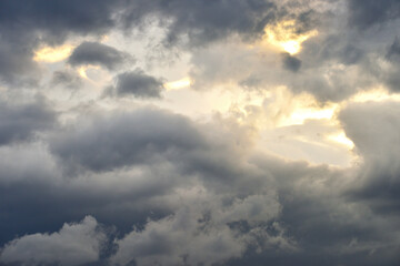 夕日を覆い隠す風に乱れる雲