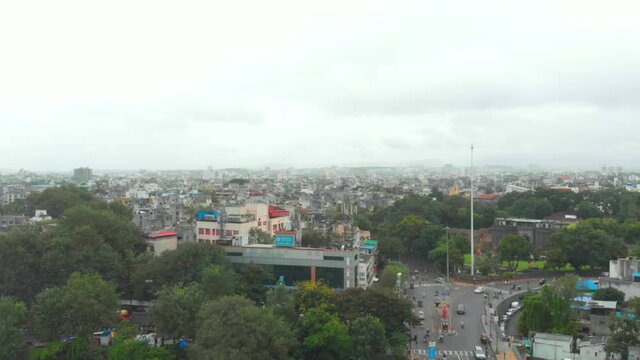 Dolly forward drone shot over Shaniwar wada traffic on Chhatrapati Shivaji bridge road Dr Hegdwar chowk old Pune city heritage site India