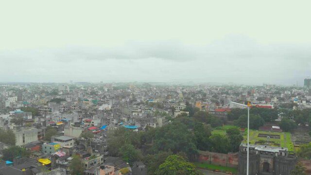 dolly back drone shot over Shaniwar wada grounds traffic Dr Hegdwar chowk old Pune city heritage site India in the rain monsoon