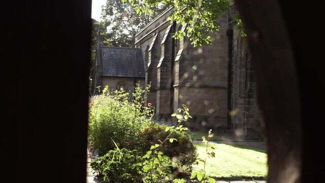 View of English church through lych gate and cobwebs  tilting shot