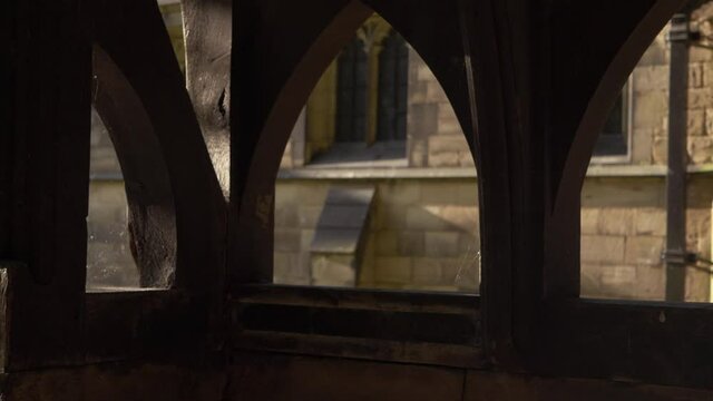 View of English church through wooden lych gate panning shot