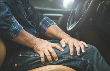 Injury or tired from long driving concept : Man use hands to hold and massage on his Thigh in the...