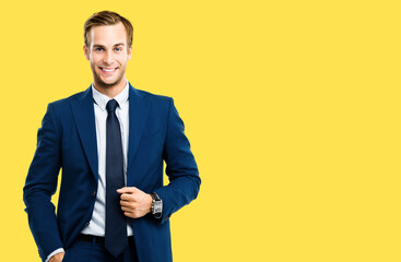 Portrait image of happy confident businessman in blue suit and tie, isolated over yellow...