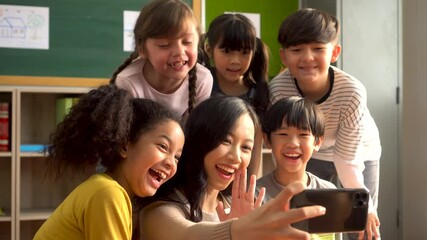 Young woman smiling with children and taking selfie photo, happiness, togetherness, education, memories. Asian school teacher photographing students on phone