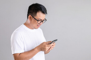 Man typing or chatting on smartphone studio shot on grey background