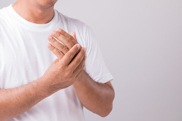 Close up man touching palm and feeling a pain. Studio shot isolated on grey background with copy...