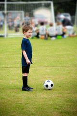 Obraz premium Happy young boy playing organized soccer
