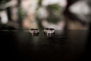 wedding rings lie on a dark table