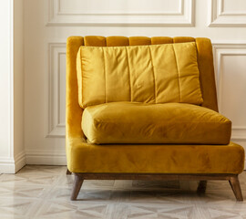 Yellow cozy armchair in a white interior. Close-up.