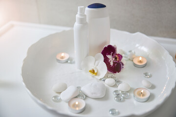 Obraz na płótnie Canvas Set for spa procedure with orchids, shower gel and lotion