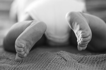 Tiny Newborn Baby's feet on female Shaped hands closeup. - 382061637