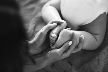 Mother's hands with tiny baby feet, closeup - 382061667