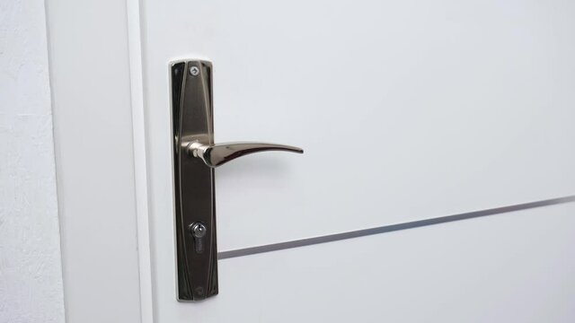 The man opens the door of the room with the key.