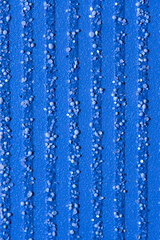Fototapeta na wymiar Abstract blue background with textured splashes of small particles, pebbles and glitter, vertical stripes.
