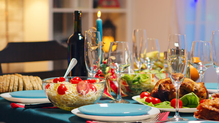 Traditional food for christmas celebration of friends. Candles on the table. Xmas celebration in decorated room full of globe decorations and christmas tree with fireplace, big festive dinner meal for