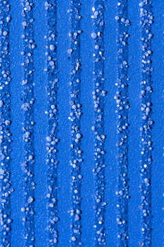Abstract blue background with textured splashes of small particles, pebbles and glitter, vertical stripes. © Anelo